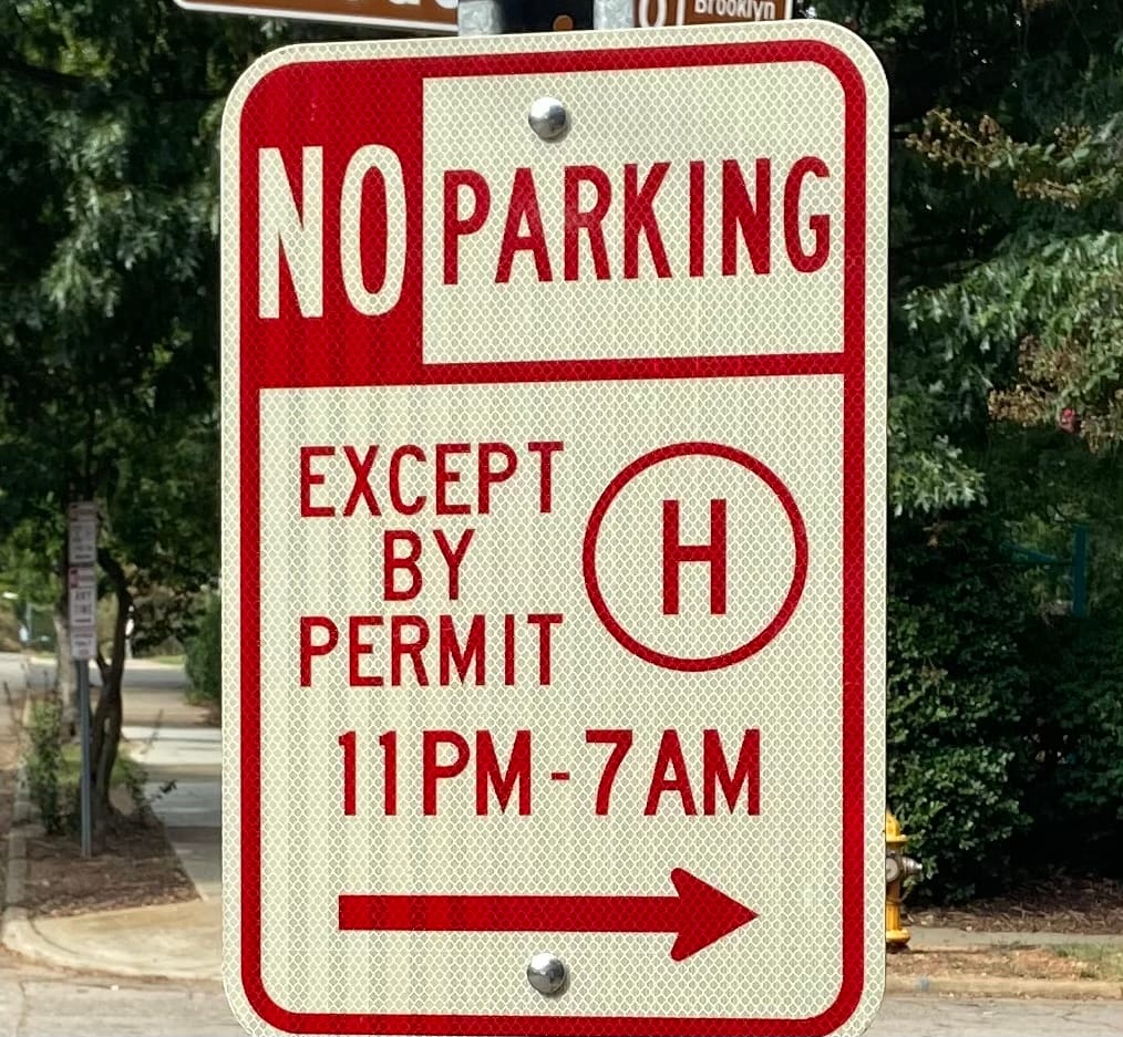 Parking sign showing No Parking Except By Permit 11PM–7AM